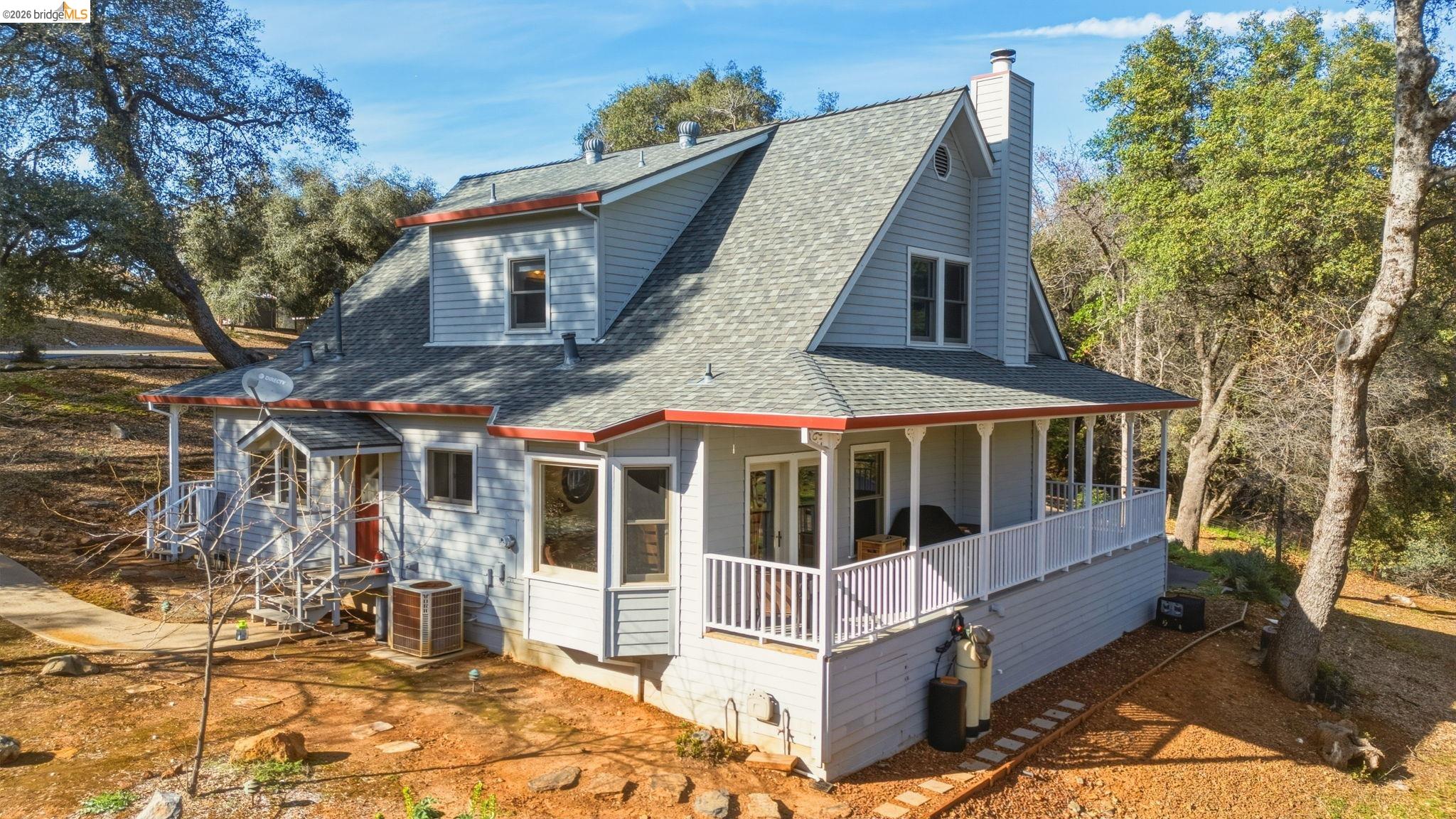 23401 Italian Bar Road Columbia, CA 95310 - Photo 23 of 49 a view of a white house with large windows and a small yard