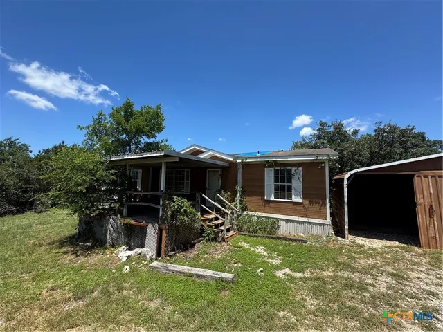 a view of a house with backyard and porch