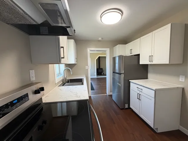 a kitchen with a refrigerator and a stove top oven