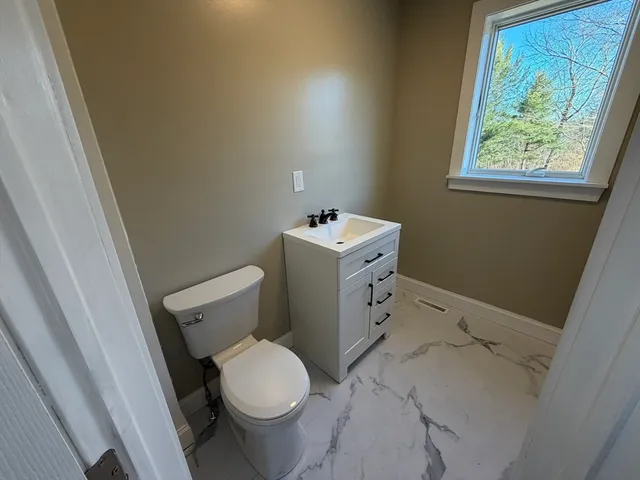 a bathroom with a sink toilet and window