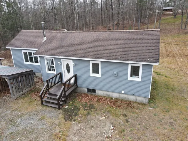 a aerial view of a house with a yard and wooden fence