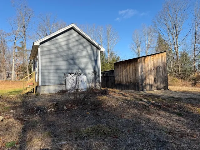a view of a house with backyard and trees