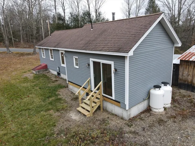 a view of a small house with yard and tree s
