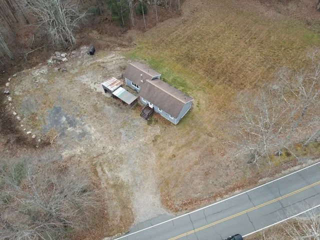 an aerial view of a house with a yard and covered with snow