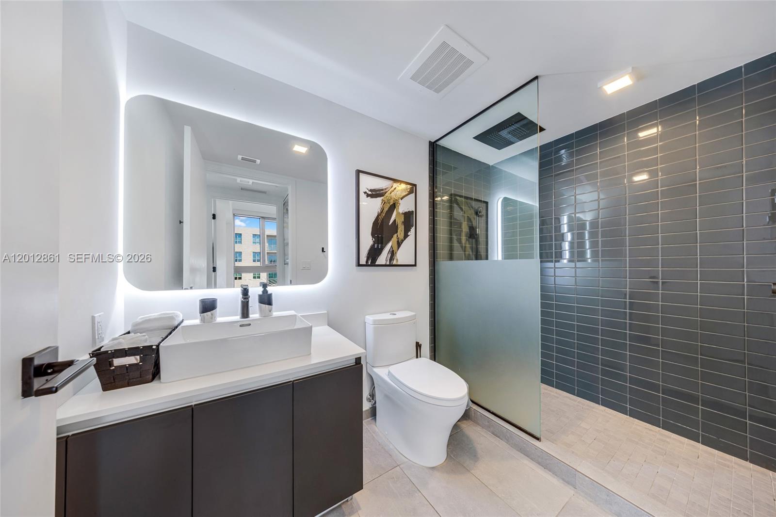 227 Northeast 2nd Street, Unit 1909 Miami, FL 33132 - Photo 5 of 18 a bathroom with a sink a toilet a mirror and shower