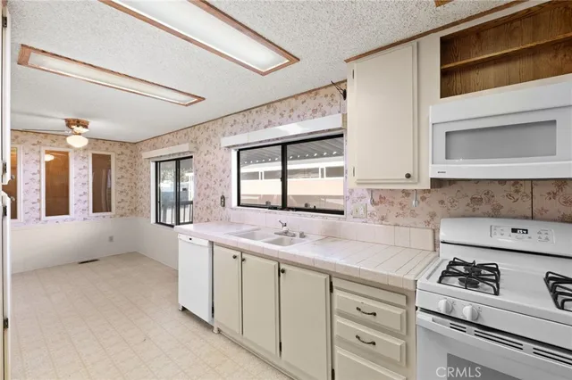 a kitchen with white cabinets and white appliances