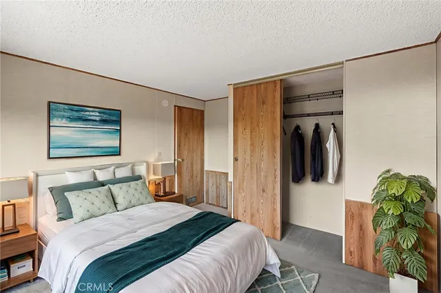 a bedroom with a bed and a painting on the wall