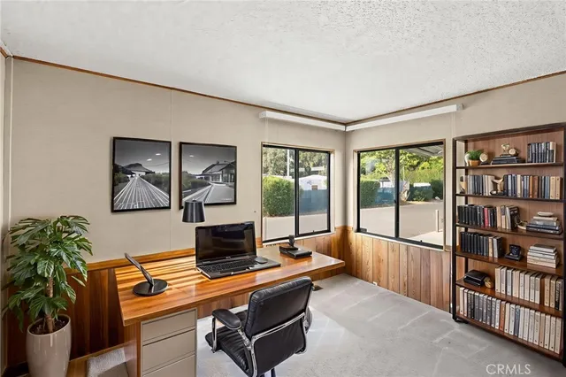 a living room with furniture a bookshelf and a large window
