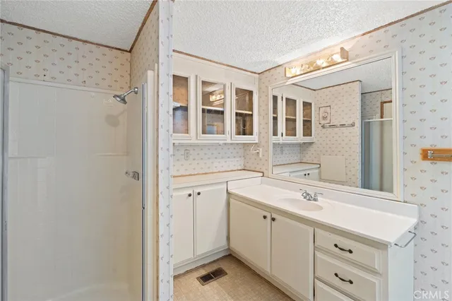a bathroom with a granite countertop sink mirror and shower