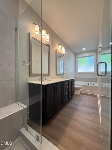 a bathroom with a double vanity sink toilet and shower
