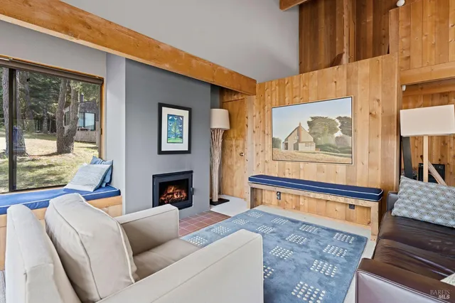 a living room with furniture a fireplace and a large window