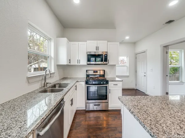 a kitchen with granite countertop a sink and steel appliances