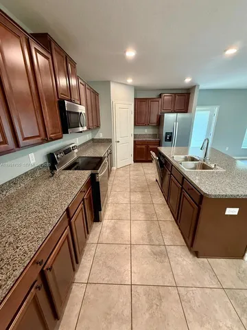 a kitchen with stainless steel appliances granite countertop a sink stove and cabinets