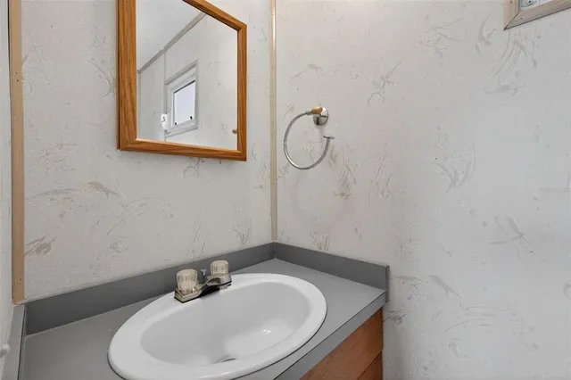a bathroom with a granite countertop sink and a window