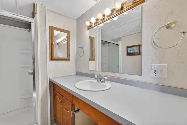 a bedroom with a bed a dresser and a chandelier