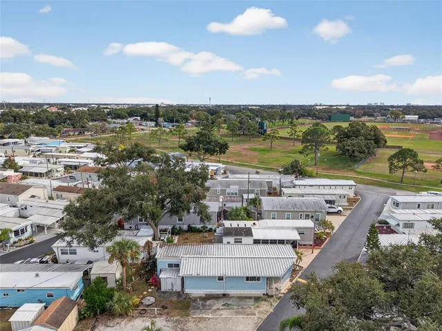 a view of a brick wall with plants and large trees