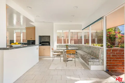 a large white kitchen with granite countertop a large window and a counter space