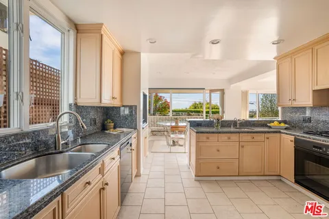 a kitchen with sink a stove and cabinets