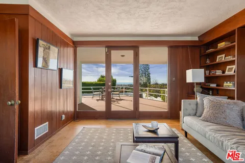 a living room with furniture and a floor to ceiling window