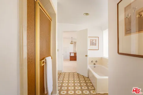 a spacious bathroom with a double vanity sink a mirror a bathtub and shower