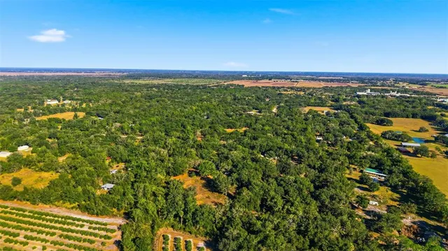 an aerial view of a houses with a yard and lake view