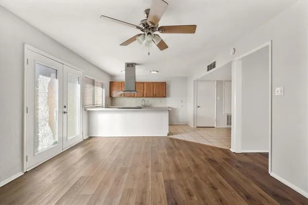 a view of a kitchen with wooden floor and a ceiling fan