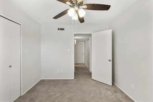 an empty room with chandelier fan