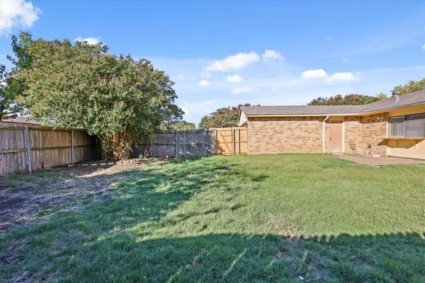 a view of a house with a backyard and a tree