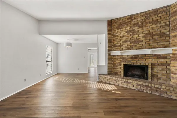a view of a livingroom with wooden floor and a fireplace