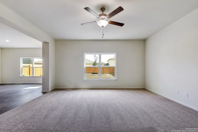 an empty room with a window and a ceiling fan