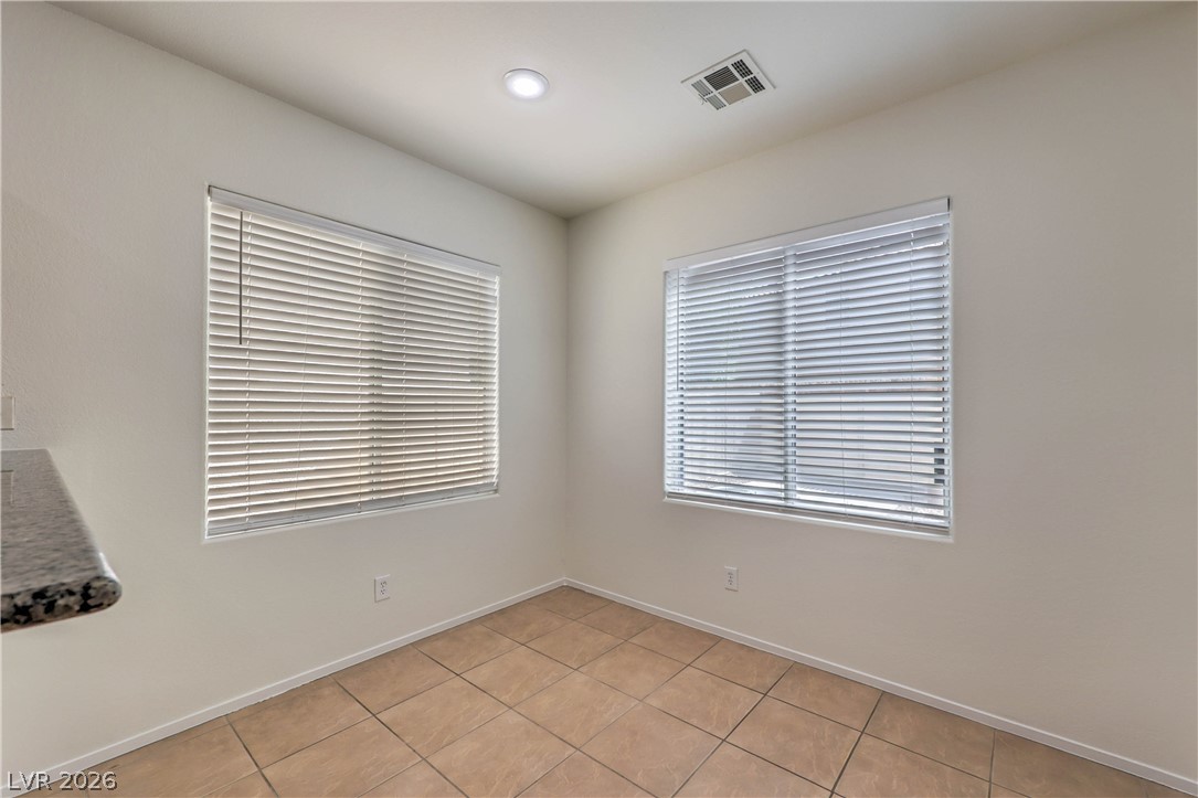 10939 Paradise Road Henderson, NV 89052 - Photo 12 of 36 Recessed lighting illuminates this versatile space, featuring durable tile flooring and natural light from two well-placed windows.