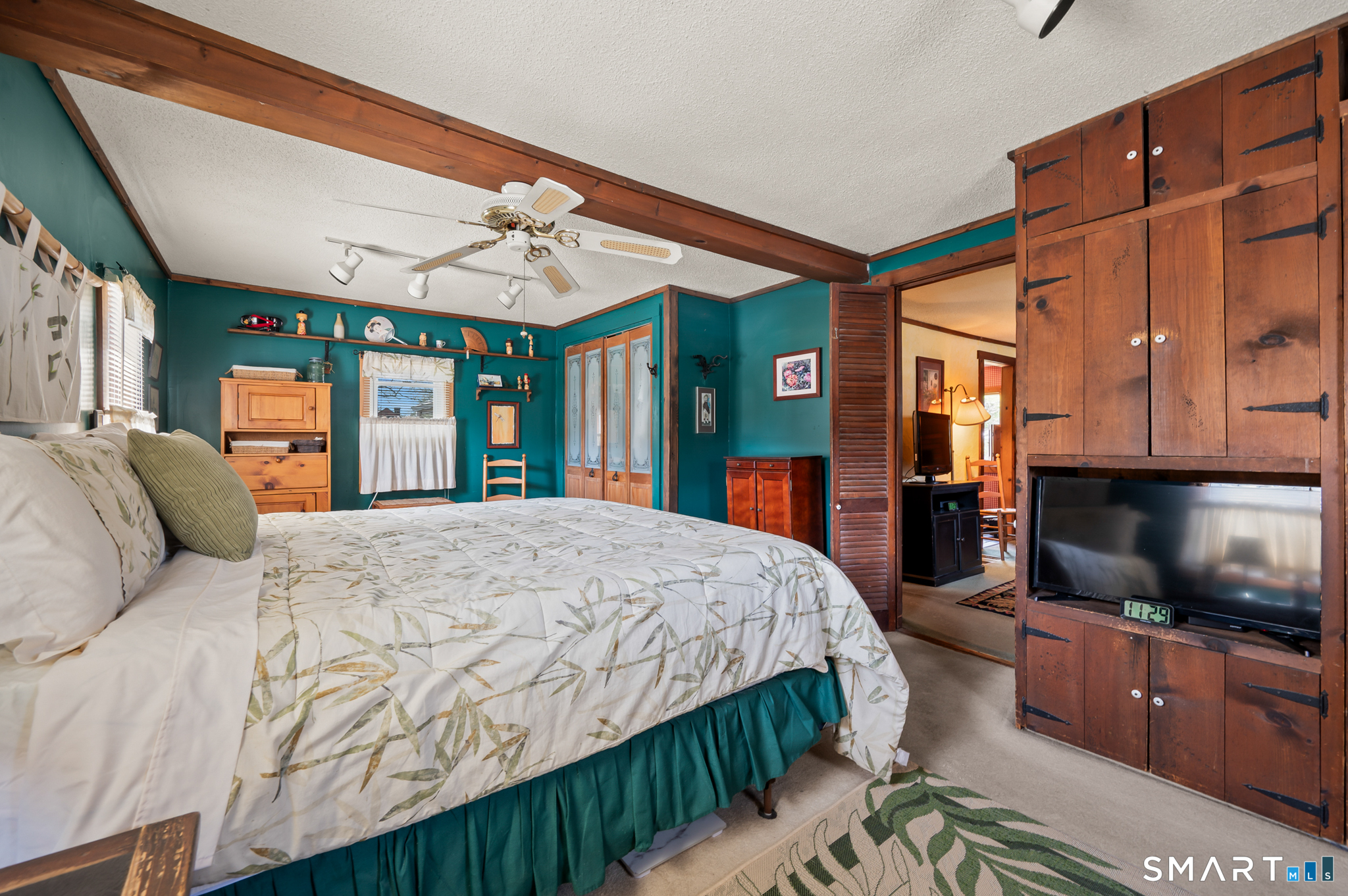 12 Booth Road Enfield, CT 06082 - Photo 12 of 30 a spacious bedroom with a large bed a flat screen tv and a chandelier