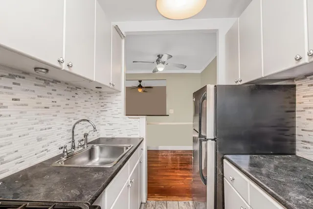 a kitchen with stainless steel appliances granite countertop a sink and a refrigerator