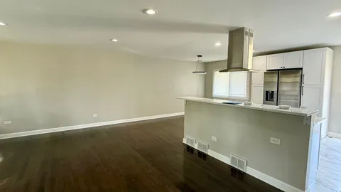 an empty room with wooden floor and a window