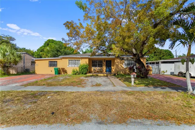 a view of a yard with a house and a tree