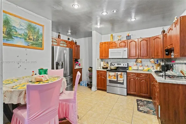 a kitchen with stainless steel appliances kitchen island granite countertop a refrigerator and a stove top oven