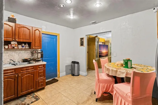 a kitchen with stainless steel appliances kitchen island granite countertop a table chairs in it and a window