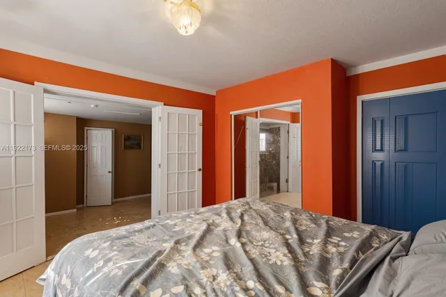 a bedroom with bed and mirror