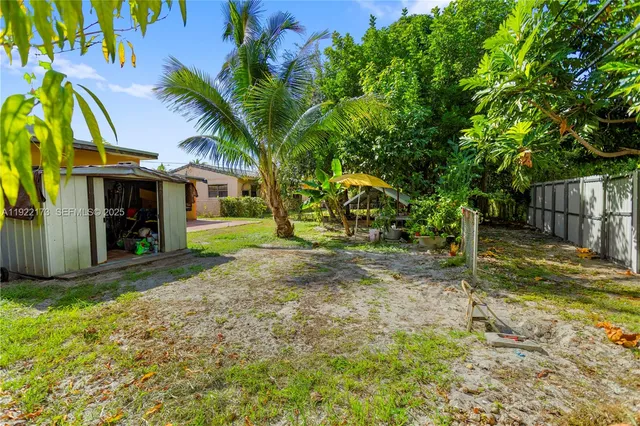 a backyard of a house with plants and tree
