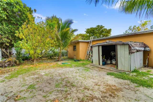 a backyard of a house with table and chairs