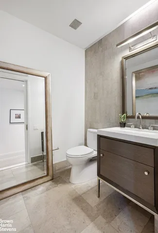 a bathroom with a toilet a sink and mirror