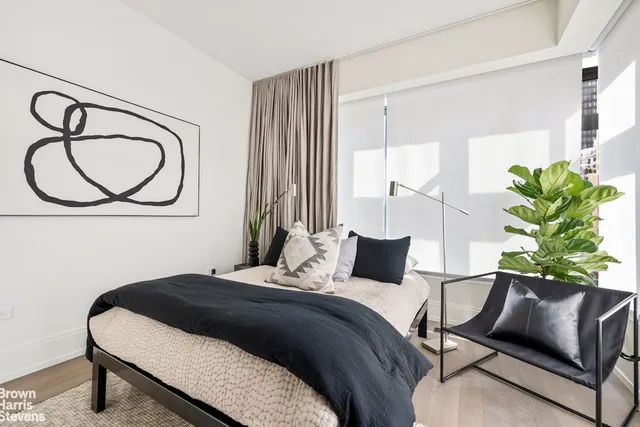 a bedroom with a bed potted plant with the window