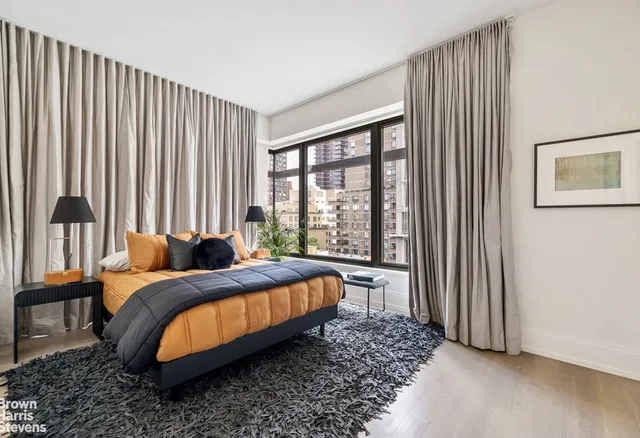 a bedroom with bed and a large window