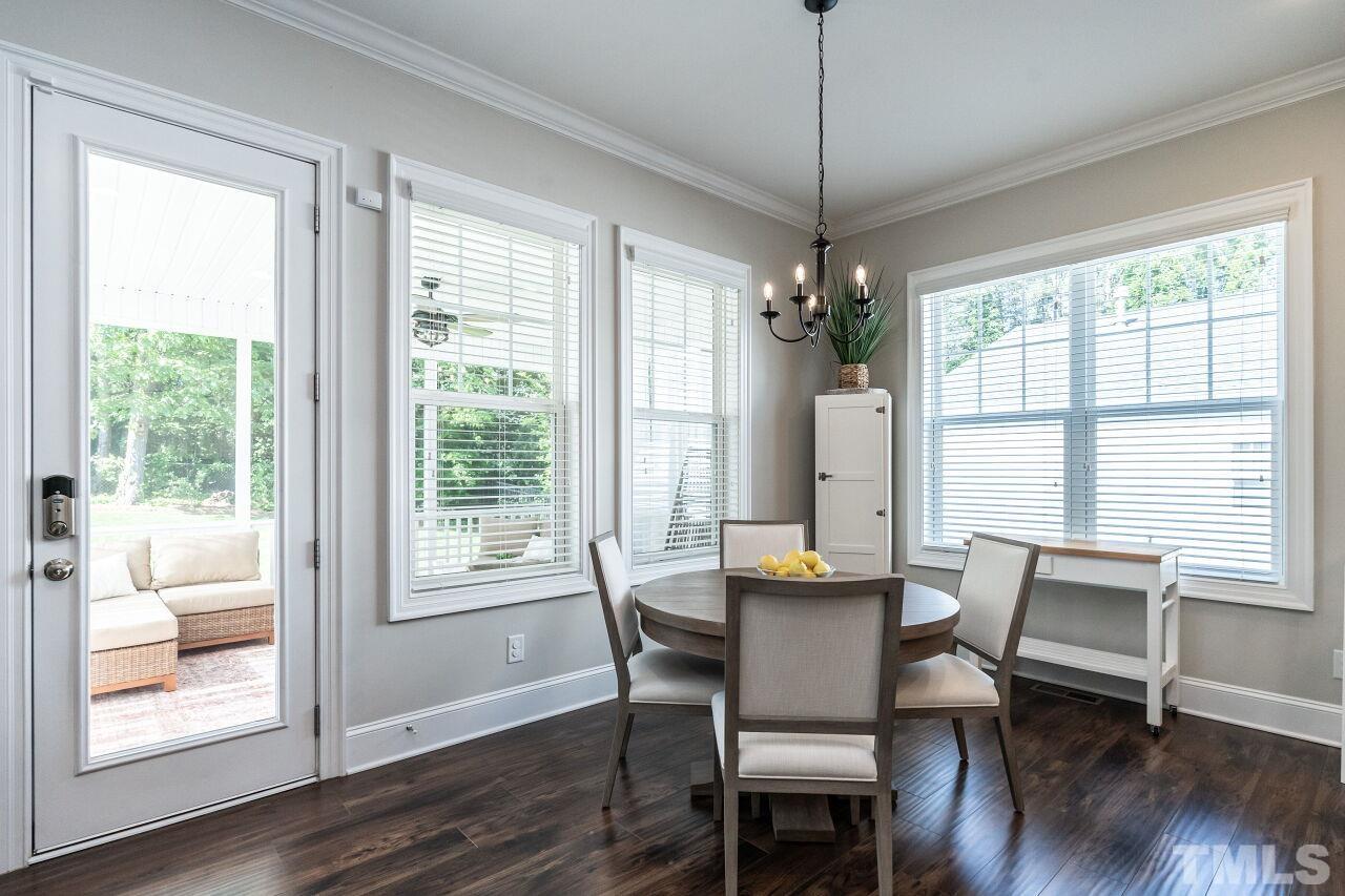 3034 Adonis Circle Raleigh, NC 27612 - Photo 13 of 46 a dining room with wooden floor a chandelier a glass table and chairs