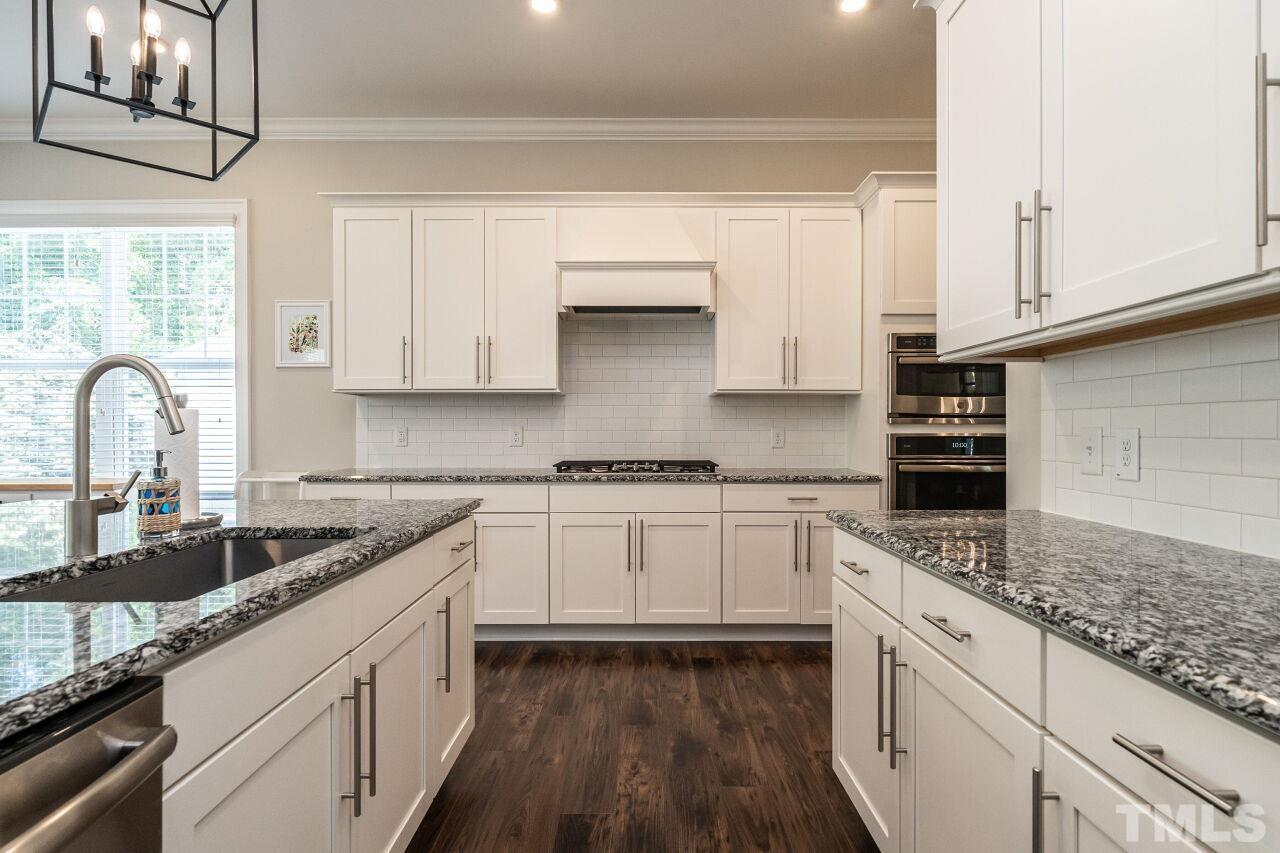3034 Adonis Circle Raleigh, NC 27612 - Photo 16 of 46 a kitchen with granite countertop white cabinets and white appliances