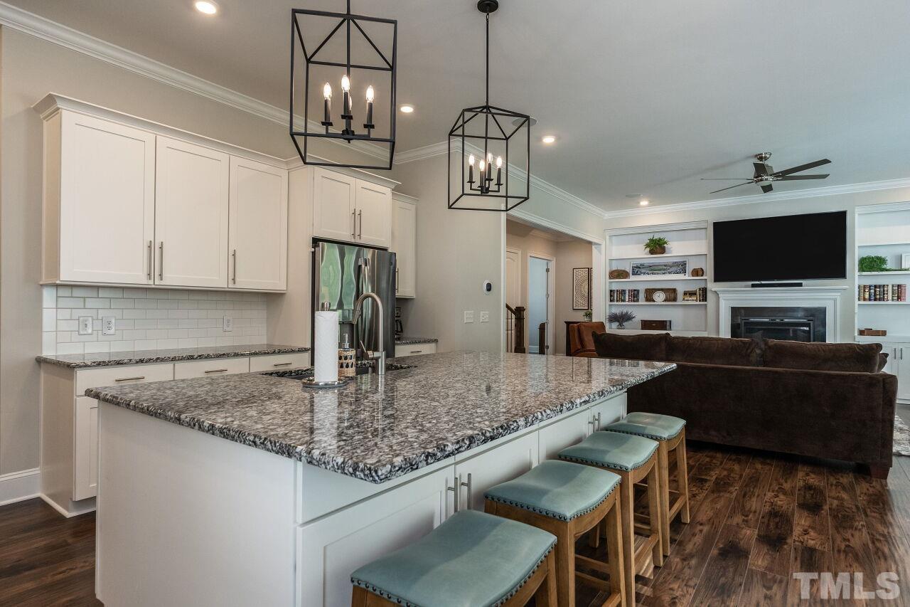 3034 Adonis Circle Raleigh, NC 27612 - Photo 17 of 46 a kitchen with stainless steel appliances granite countertop a stove a refrigerator a kitchen island a sink dishwasher a dining table and chairs with wooden floor
