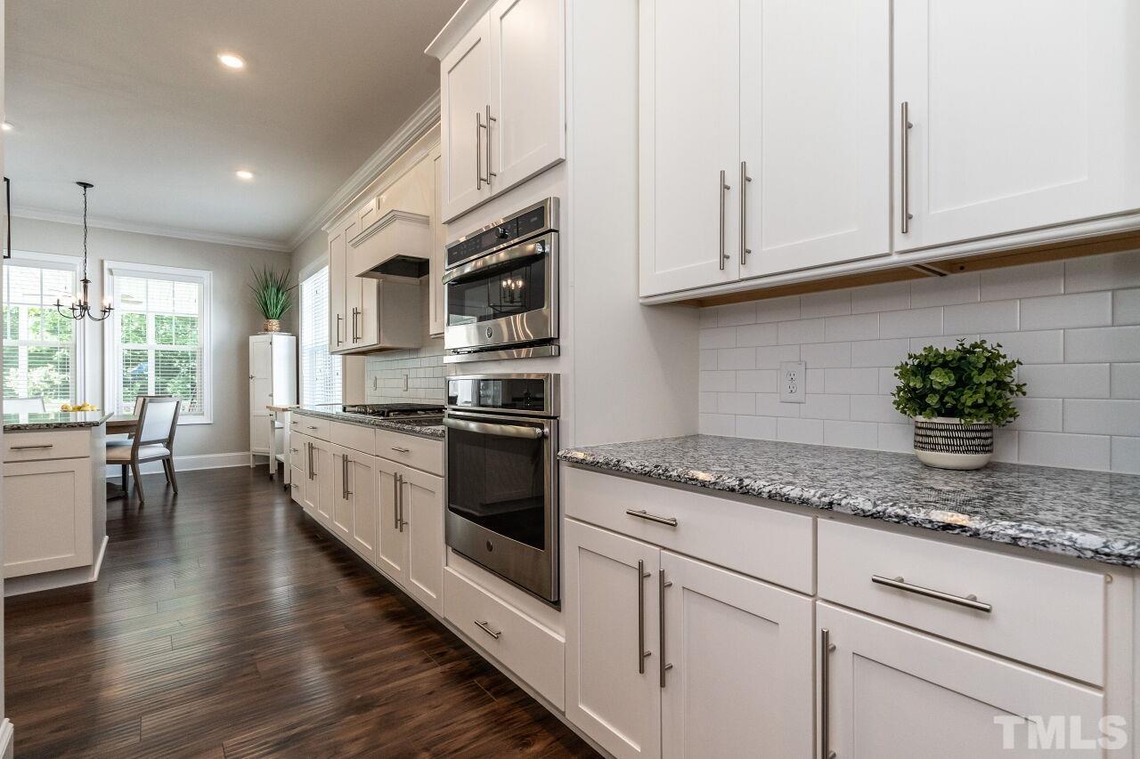 3034 Adonis Circle Raleigh, NC 27612 - Photo 18 of 46 a kitchen with granite countertop white cabinets and white appliances