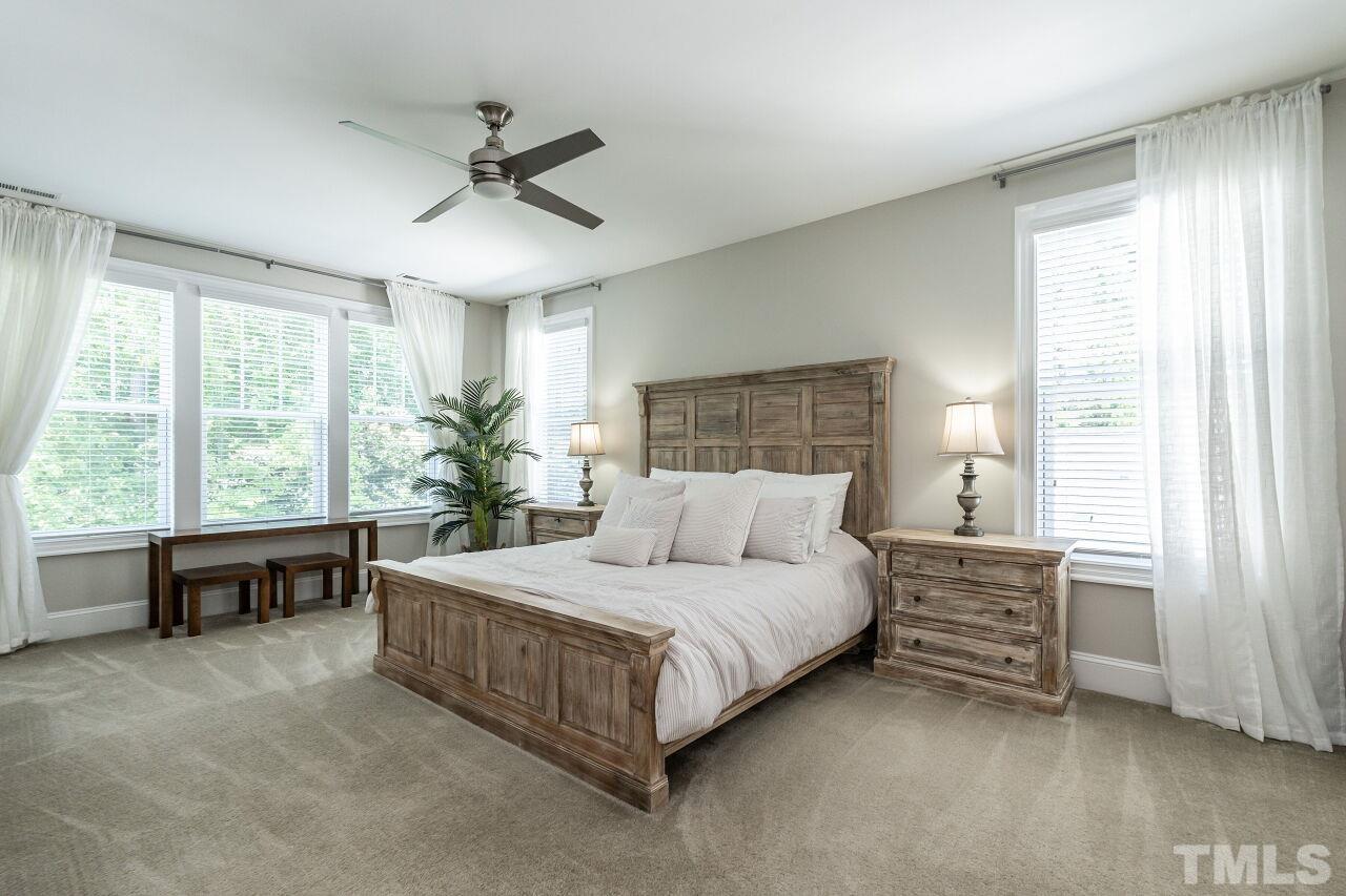 3034 Adonis Circle Raleigh, NC 27612 - Photo 24 of 46 a bedroom with a large bed and a chandelier fan