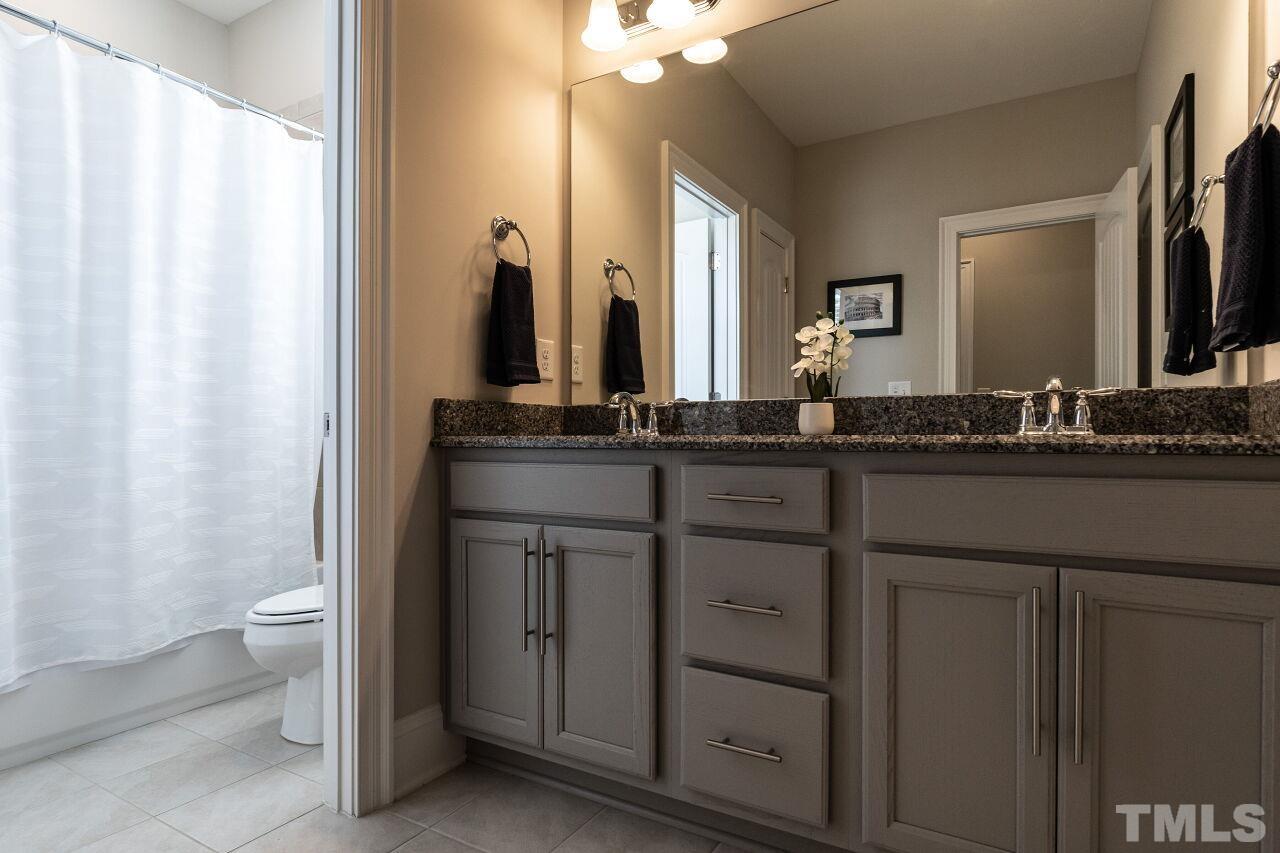 3034 Adonis Circle Raleigh, NC 27612 - Photo 33 of 46 a bathroom with a double vanity sink and a mirror