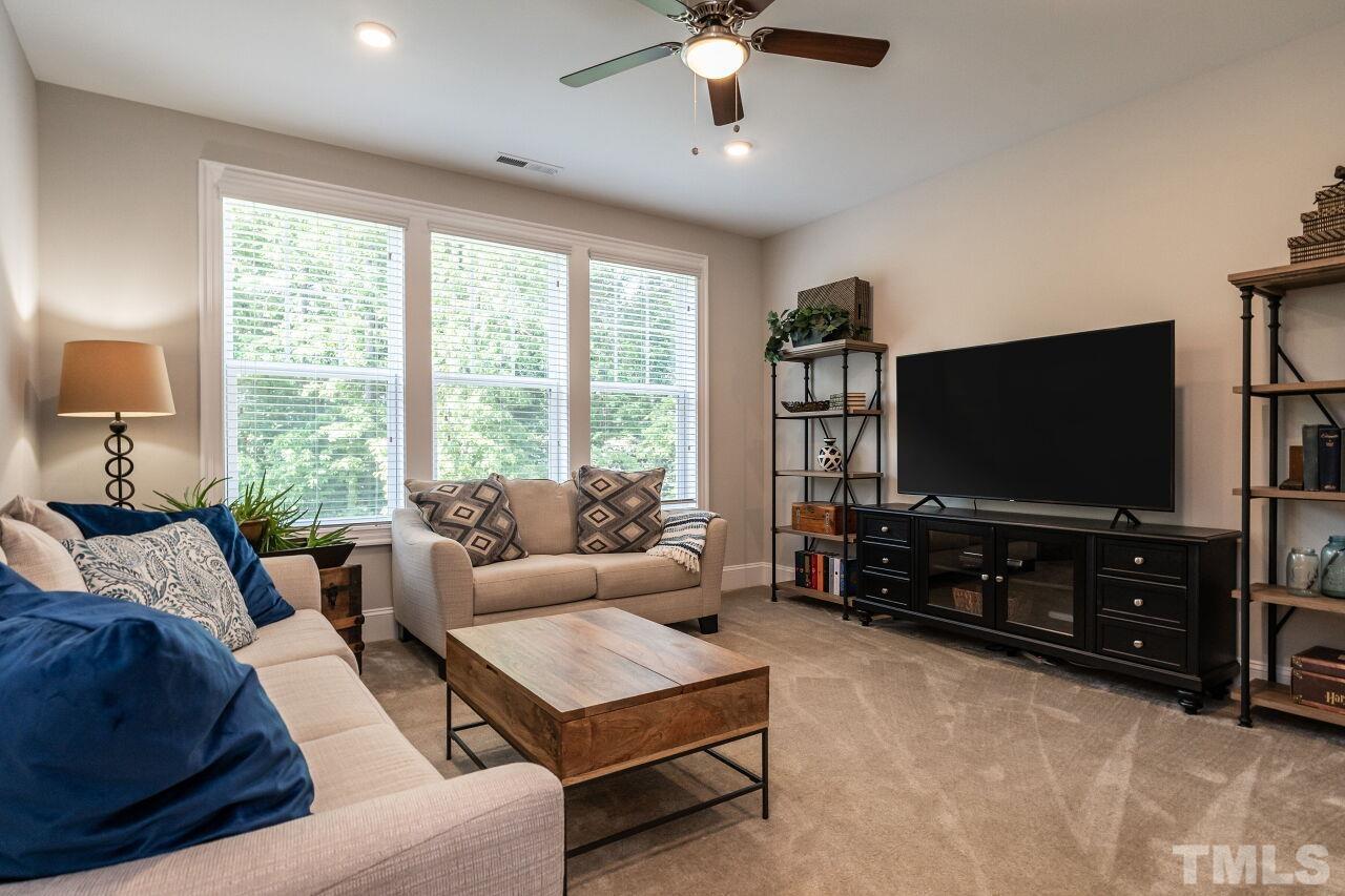 3034 Adonis Circle Raleigh, NC 27612 - Photo 35 of 46 a living room with furniture and a flat screen tv